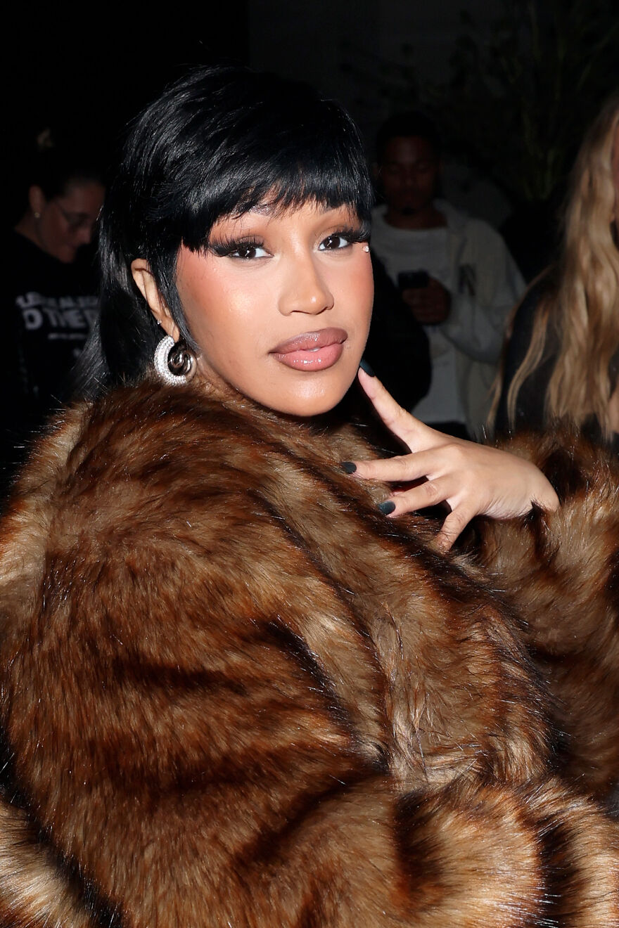 Cardi B wearing a brown fur coat and hoop earrings, posing confidently, highlighting her rising net worth and music influence. Cardi B wearing a brown fur coat and hoop earrings, posing confidently, highlighting her rising net worth and music influence.
