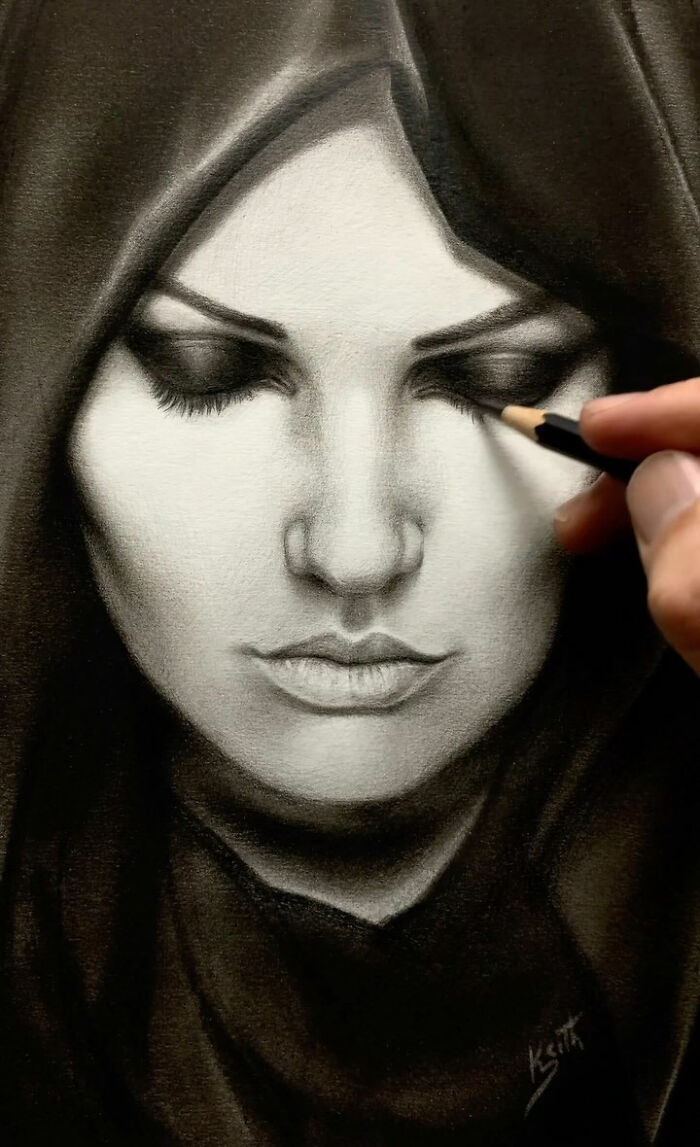 Hand drawing a detailed pencil portrait of a woman with closed eyes, capturing every tiny detail in the shading.