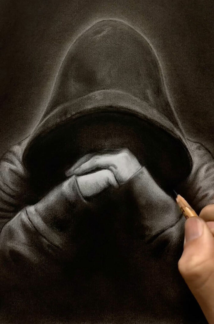 Hand drawing an incredible pencil portrait of a hooded figure with detailed shading capturing every tiny detail.