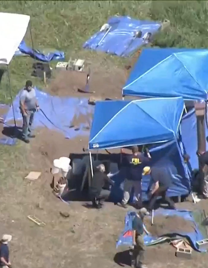 FBI agents and investigators excavate a rural site with tents, collecting evidence in a doomsday cult crime investigation. FBI agents and investigators excavate a rural site with tents, collecting evidence in a doomsday cult crime investigation.