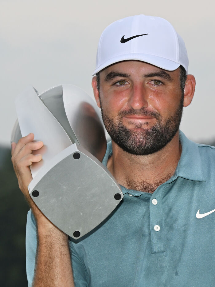 Male athlete in Nike cap holding a silver trophy, showcasing highest paid athletes 2025 in a celebratory moment outdoors.