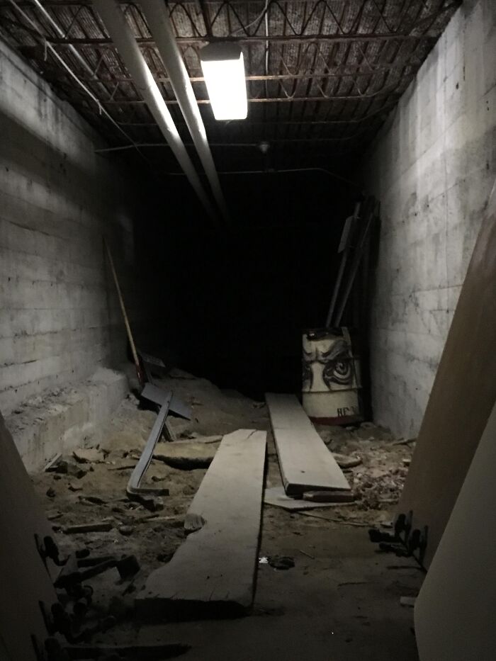 Dark underground tunnel with debris and wooden planks, illustrating terrifying true stories from people who explore beneath our feet.