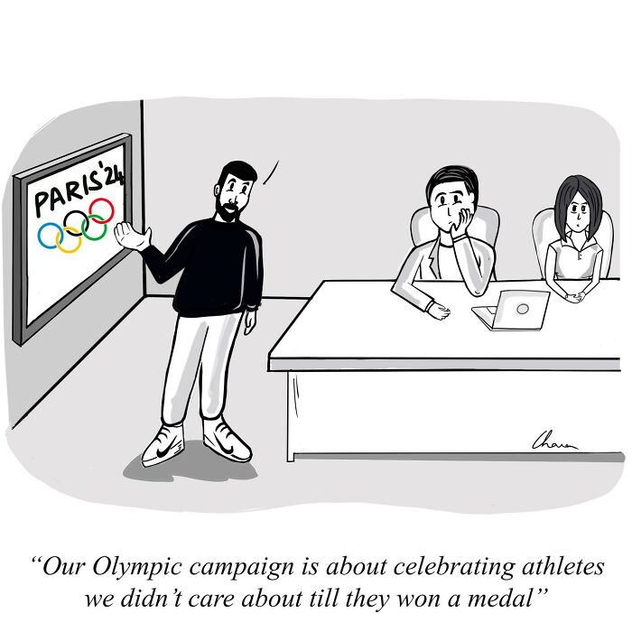 Man presenting Olympic campaign to uninterested team, one-panel comic capturing humor in today’s world.