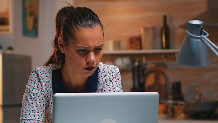 Woman upset and focused on laptop screen, dealing with family’s dirty laundry aired out online by stalker half-sis. Woman upset and focused on laptop screen, dealing with family’s dirty laundry aired out online by stalker half-sis.