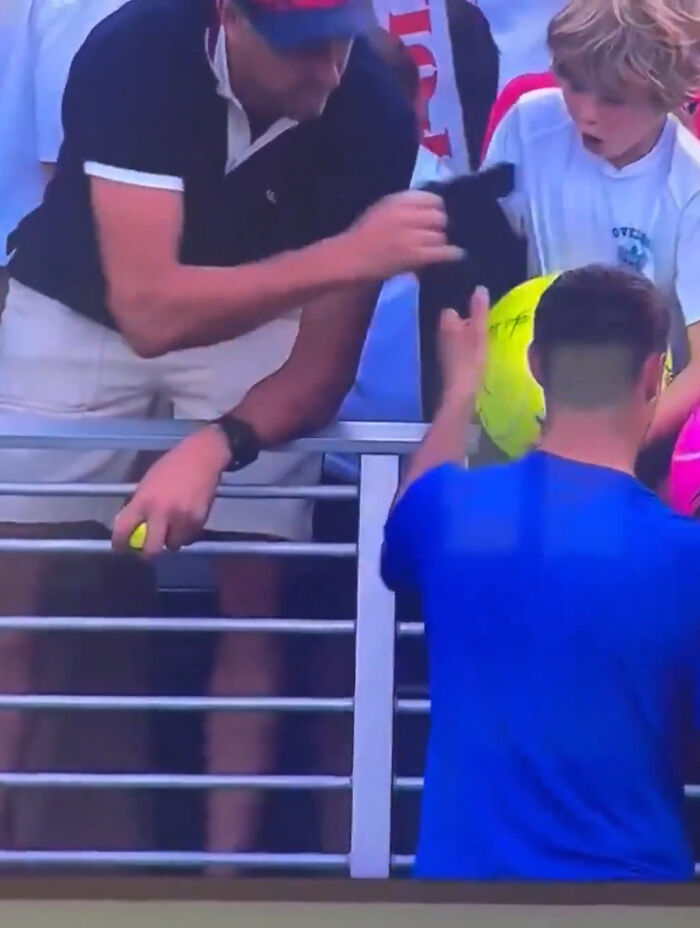 Man snatching boy's cap at US Open crowd, causing shock and attention during viral incident involving disgraced CEO. Man snatching boy's cap at US Open crowd, causing shock and attention during viral incident involving disgraced CEO.