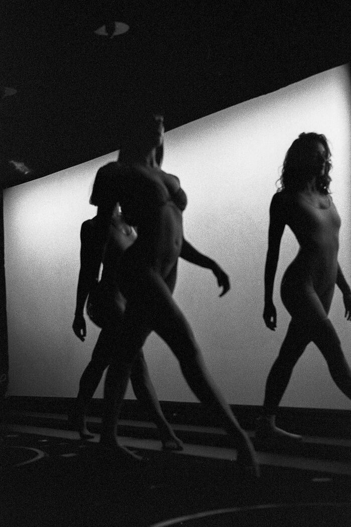 Silhouettes of dancers captured in a striking black and white analog photo highlighting movement and form.