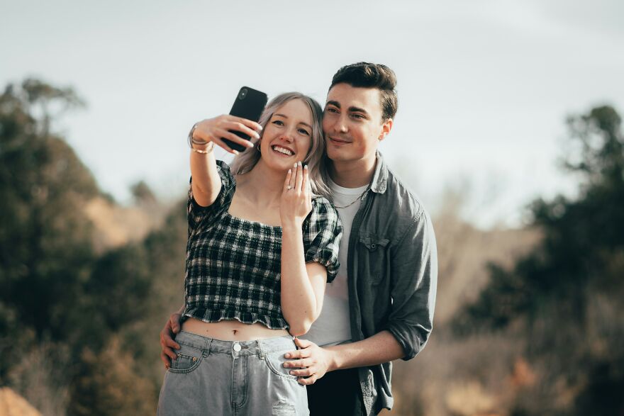 Young couple taking a selfie outdoors, smiling and embracing, illustrating red flags in a relationship masquerading as green lights. Young couple taking a selfie outdoors, smiling and embracing, illustrating red flags in a relationship masquerading as green lights.
