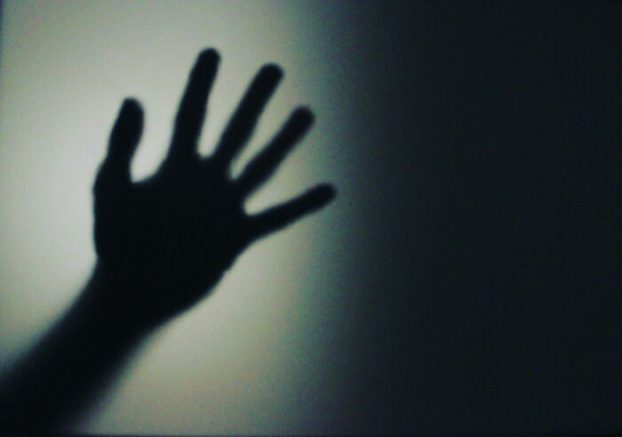 Shadow of a hand reaching out in dim light, evoking a sense of mystery for toddlers or alligator poll challenge.