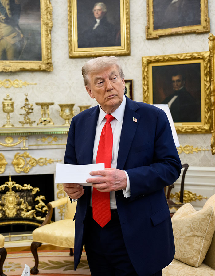 Donald Trump in a formal room holding papers, linked to Mark Zuckerberg's embarrassing hot mic moment buzz. Donald Trump in a formal room holding papers, linked to Mark Zuckerberg's embarrassing hot mic moment buzz.