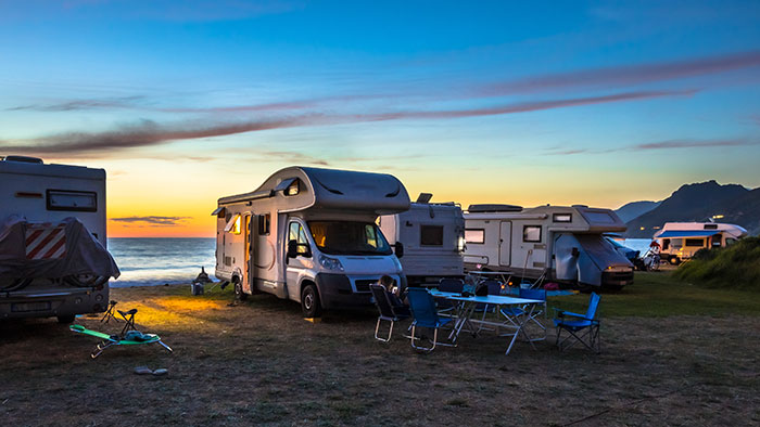 Campers and RVs parked by the beach at sunset, symbolizing a 7-year-long world trip and family reunion. Campers and RVs parked by the beach at sunset, symbolizing a 7-year-long world trip and family reunion.