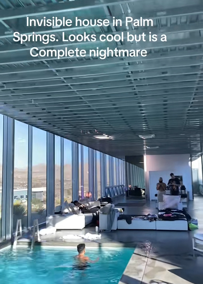 Interior view of the famous invisible house Airbnb with large glass walls and a person swimming in the pool inside. Interior view of the famous invisible house Airbnb with large glass walls and a person swimming in the pool inside.