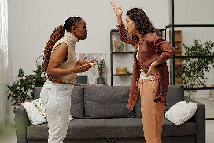 Two women angrily arguing indoors, highlighting family conflict and tension around ignoring a no-peanut rule risking anaphylaxis.