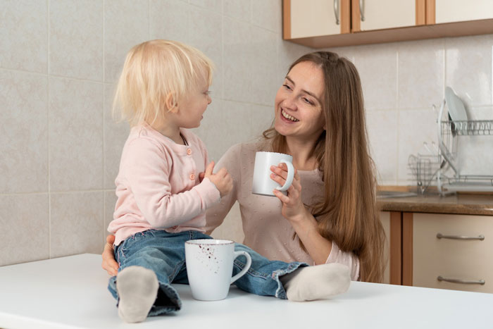 Mother and little girl in kitchen sharing a moment, highlighting concerns about eating disorder comments and childhood behavior.