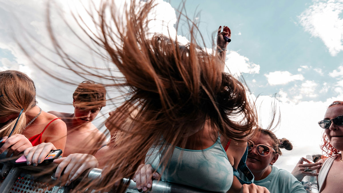 Young people enjoying a live event outdoors, capturing funny practical and heartfelt advice moments in a vibrant crowd.