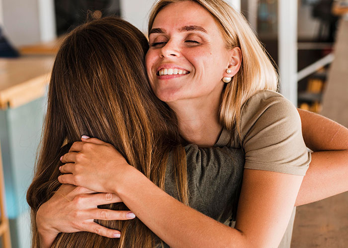 Two women hugging indoors showing friendship and trust, highlighting privacy concerns and cutting off a long-term friend. Two women hugging indoors showing friendship and trust, highlighting privacy concerns and cutting off a long-term friend.