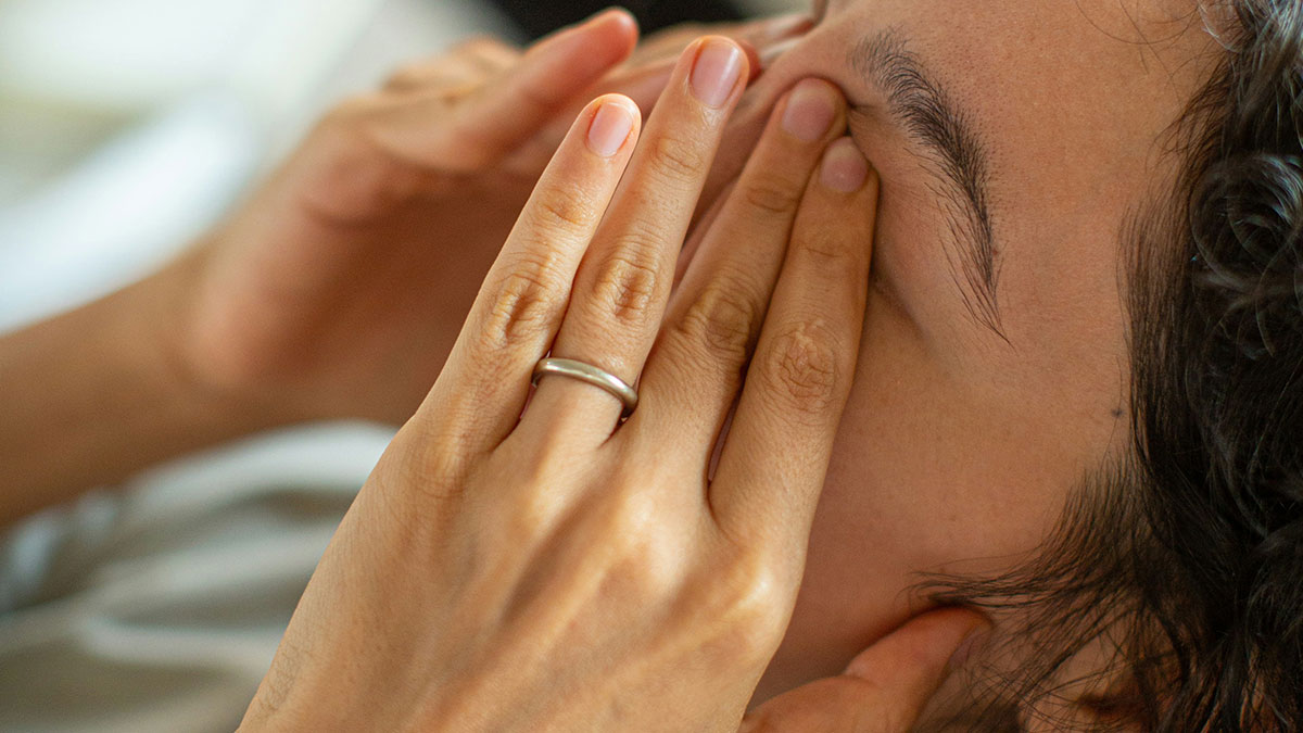 Close-up of a person overwhelmed and stressed, illustrating the impact of hustle culture on mental well-being.