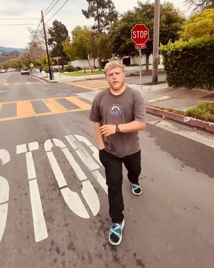 White man walking away on street near stop sign during confrontation over racial slur at library in viral video. White man walking away on street near stop sign during confrontation over racial slur at library in viral video.