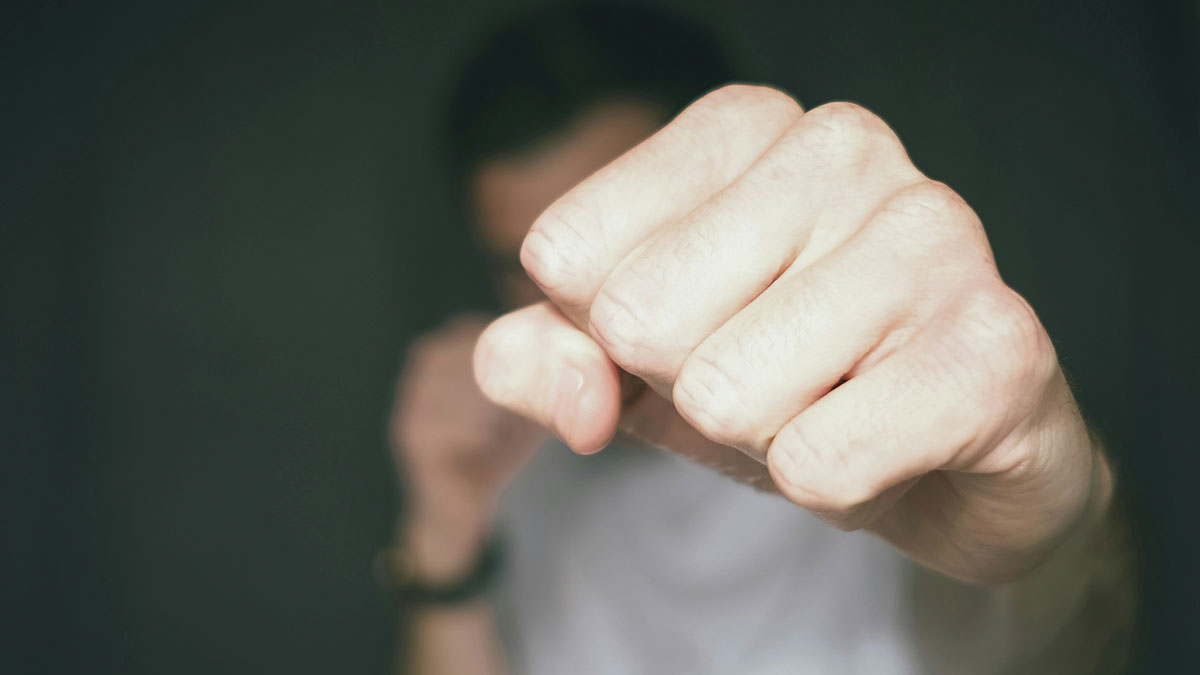 Close-up of a fist punching forward symbolizing shock and aggression related to teacher and student incident in class.