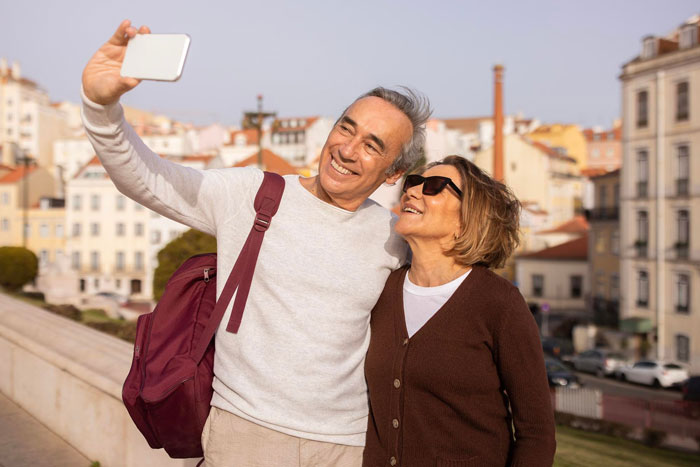 Middle-aged couple taking a selfie outdoors, smiling and enjoying the moment, relating to breaking up over photograph. Middle-aged couple taking a selfie outdoors, smiling and enjoying the moment, relating to breaking up over photograph.