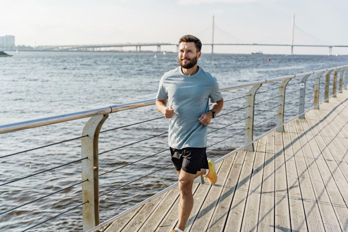 Man running along waterfront on boardwalk, representing dad preparing for marathons while mom faces heavy periods and anemia. Man running along waterfront on boardwalk, representing dad preparing for marathons while mom faces heavy periods and anemia.