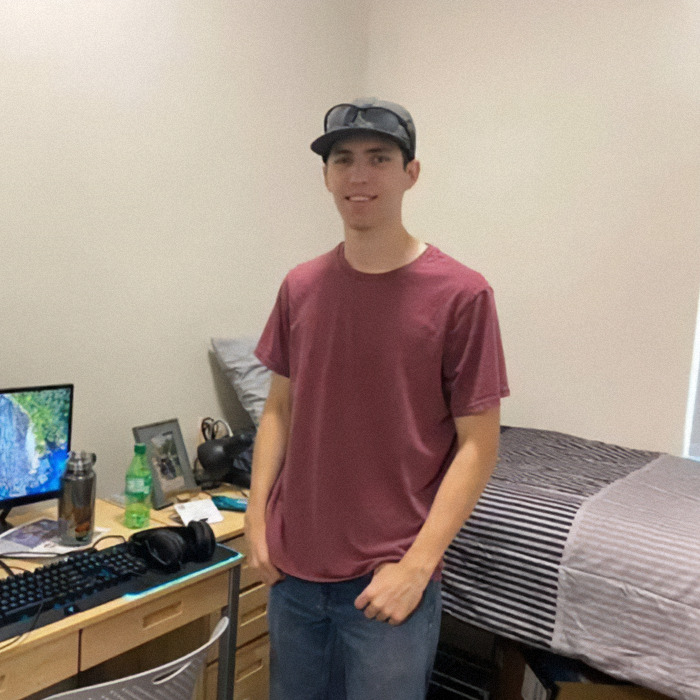 Young man standing in a casual room setting with computer gear and bed, related to Tyler Robinson exclusive photo claim. Young man standing in a casual room setting with computer gear and bed, related to Tyler Robinson exclusive photo claim.
