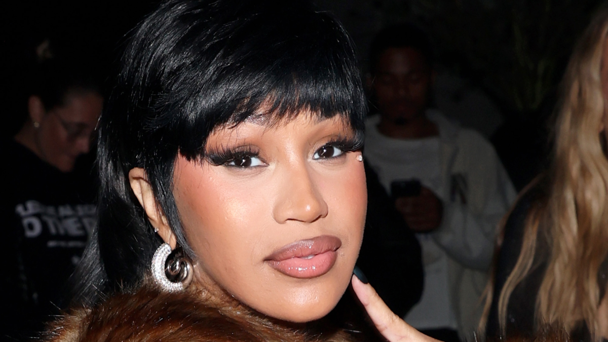 Cardi B close-up portrait wearing earrings and makeup, showcasing her rising net worth and music industry influence.