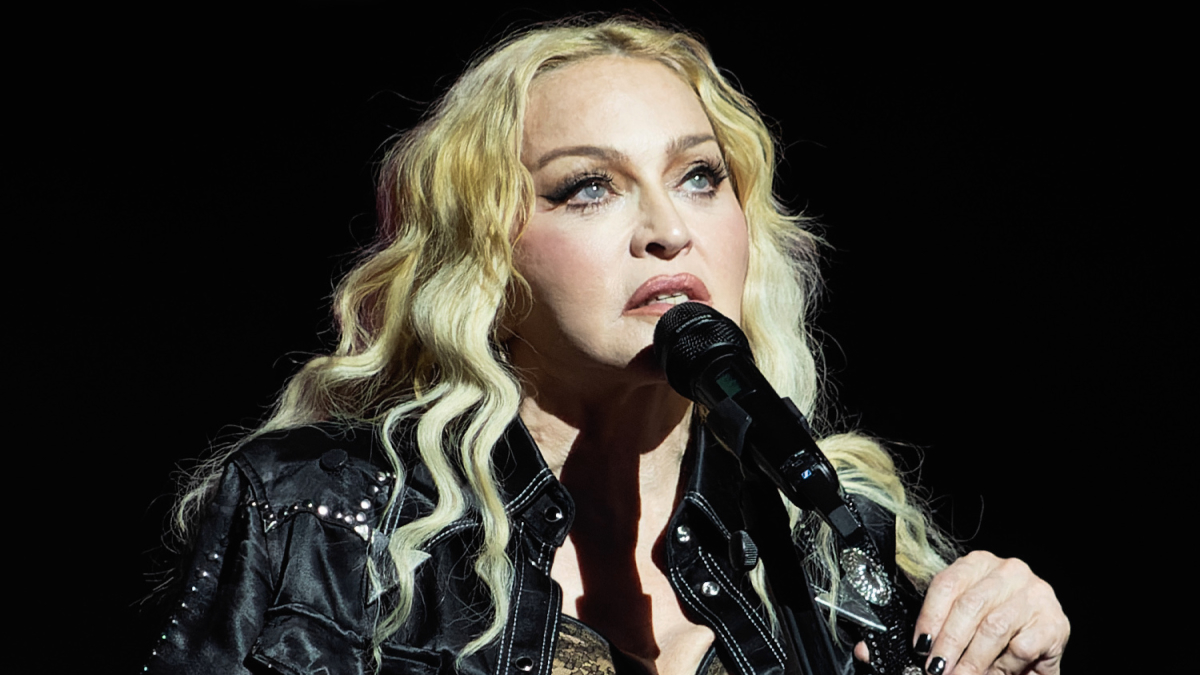 Celebrity childhood homes and beginnings shown through a close-up of a female singer performing on stage.