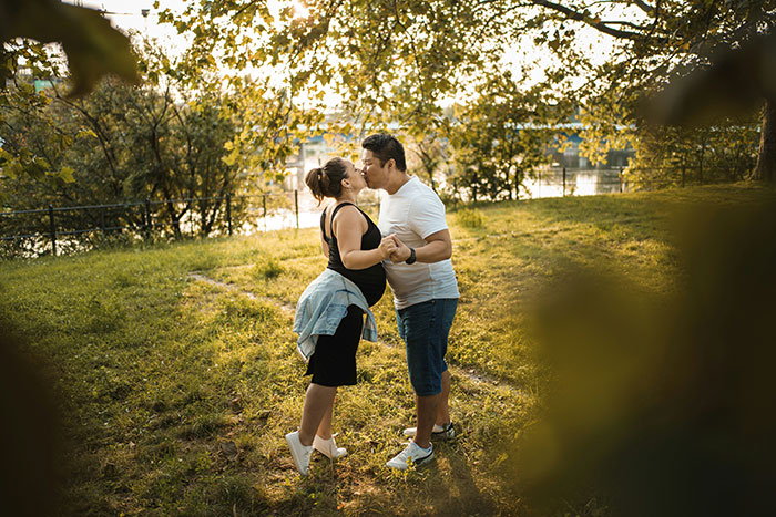 Pregnant woman and husband holding hands outdoors, highlighting risks of anaphylaxis and family conflict over peanut allergy rules.
