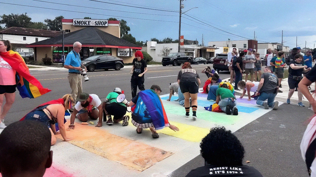 People displaying chaotic good by painting a street mural with pride flags in a community gathering.