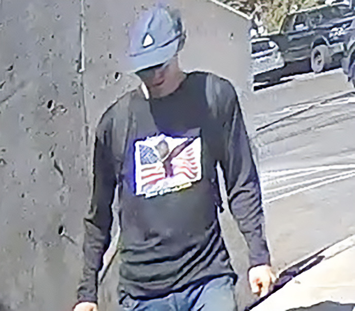 Man wearing a helmet and an American flag shirt walking outside, related to Charlie Kirk suspect Tyler Robinson court appearance. Man wearing a helmet and an American flag shirt walking outside, related to Charlie Kirk suspect Tyler Robinson court appearance.