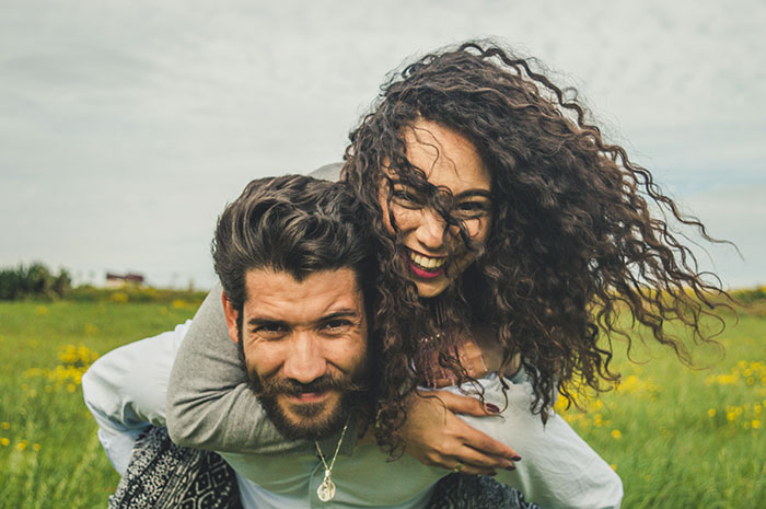 Happy couple outdoors showing love and laughter despite future MIL branding bride-to-be stupid in a field. Happy couple outdoors showing love and laughter despite future MIL branding bride-to-be stupid in a field.