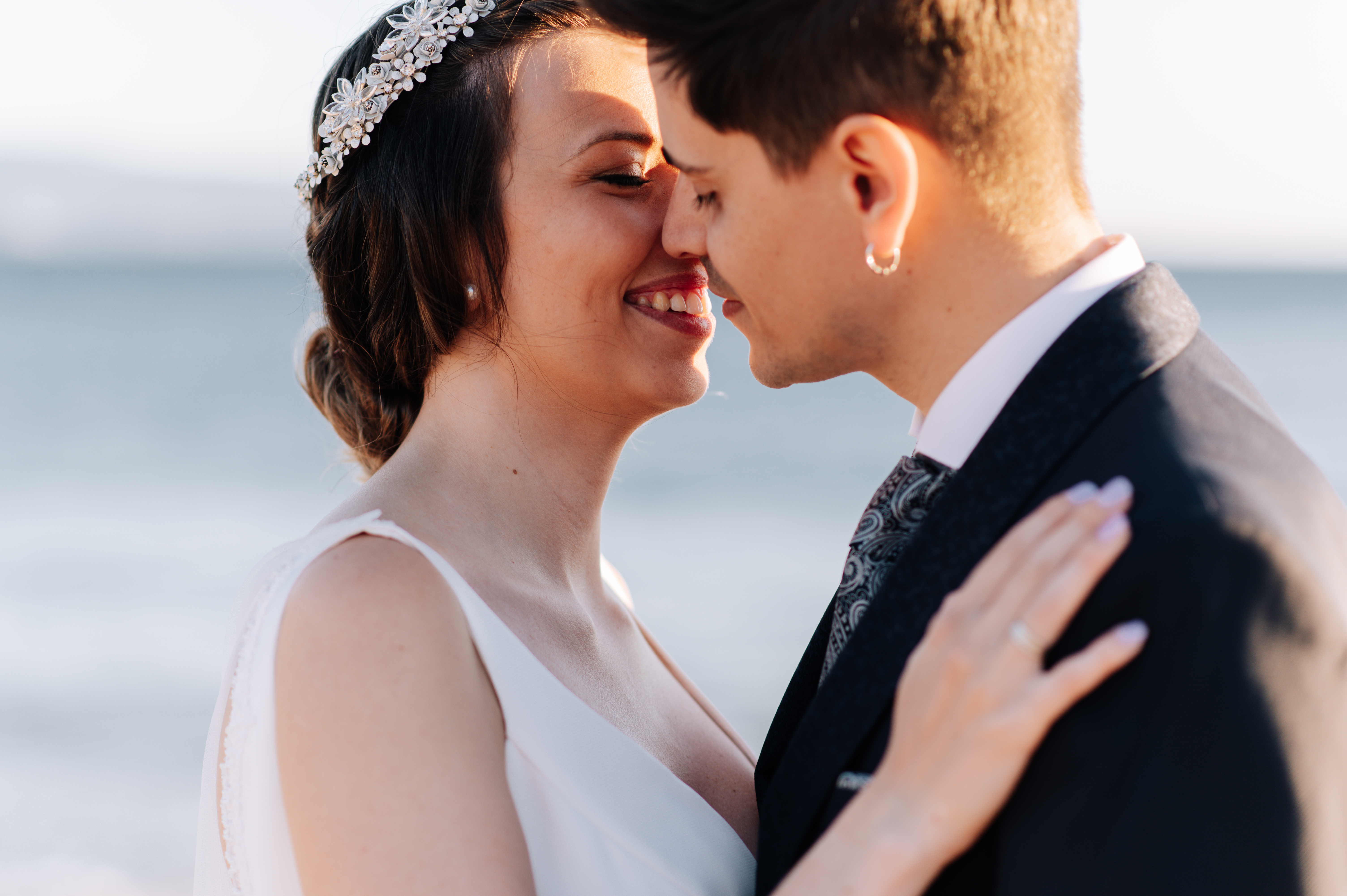 Bride and groom smiling close at wedding near the ocean, highlighting service dog refusal and wedding conflict topics