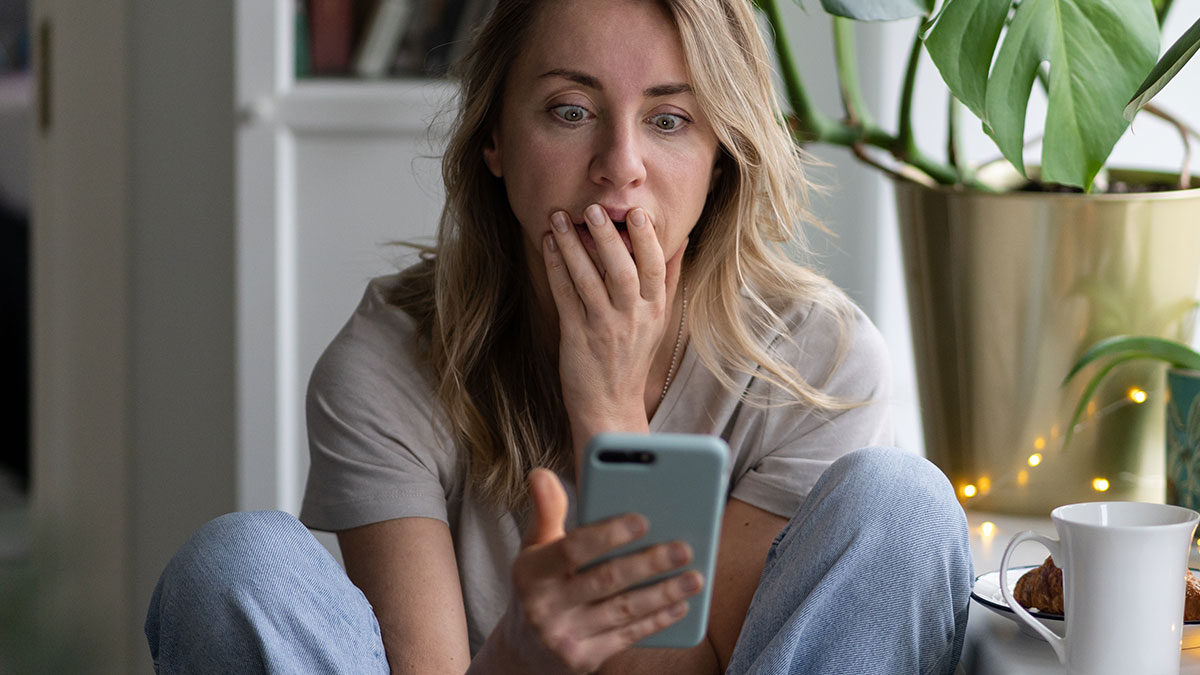 Woman reacting with shock looking at her smartphone, illustrating people being way too confident yet embarrassingly wrong.