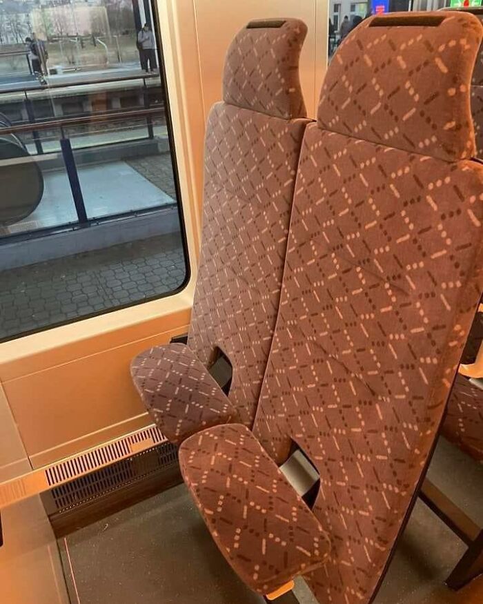 Train seats with poorly designed armrests blocking comfort, an example of construction and design fails.