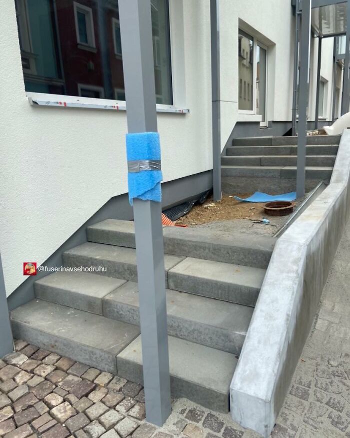 Staircase construction with an obstructing pole in the middle, showcasing flawed design and poor construction choices.