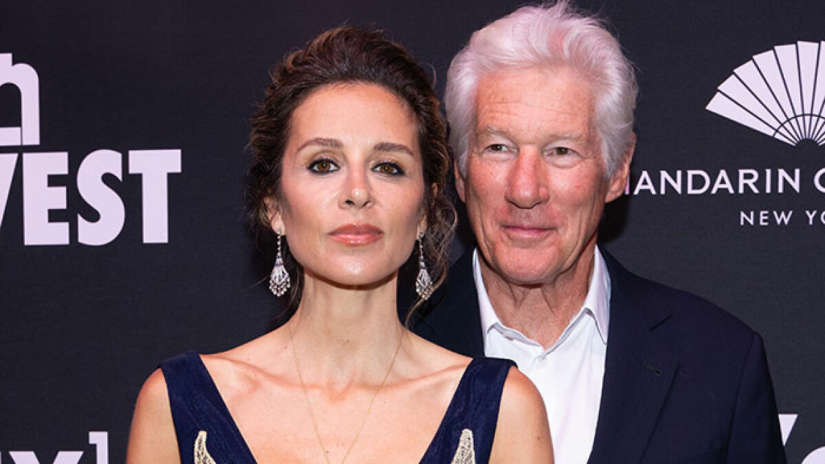 Paul Simonu2019s daughter and Richard Gere posing together at a formal event with a black backdrop and logos.