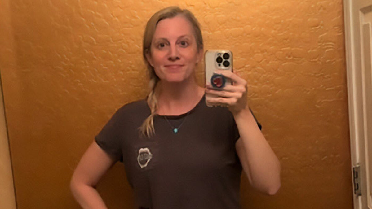 Woman taking a mirror selfie looking shocked after her best friend ends friendship over mom shorts style.