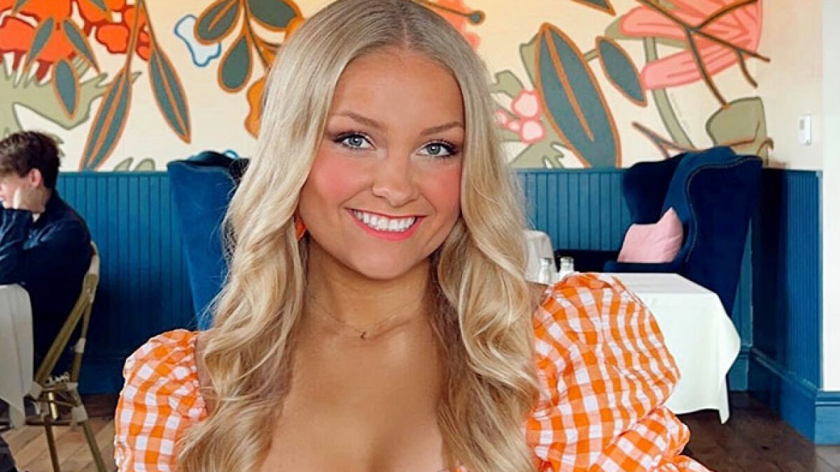 Young blonde cheerleader smiling indoors wearing an orange checkered top, related to newborn body hidden in closet case.
