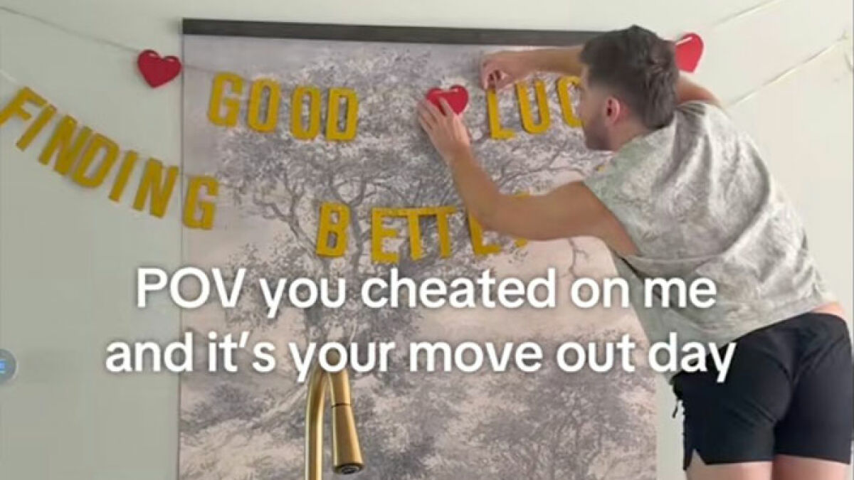Man hanging heart decorations beside good luck letters in mariachi revenge scene for cheating ex viral video.