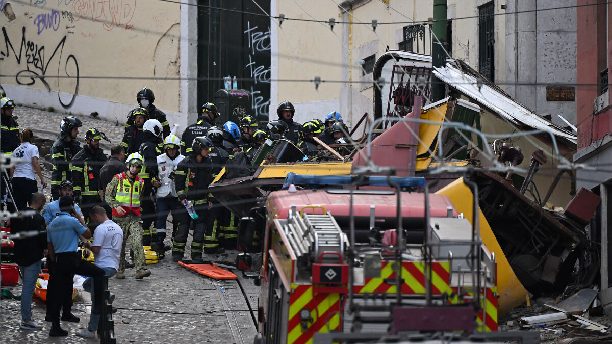 Emergency responders at the scene of an iconic tram crash after it plunged down hill and hit a building in Portugal