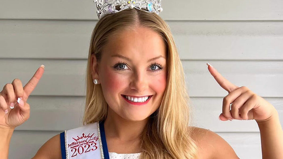 Cheerleader wearing a crown and sash, smiling confidently before court appearance related to newborn case.