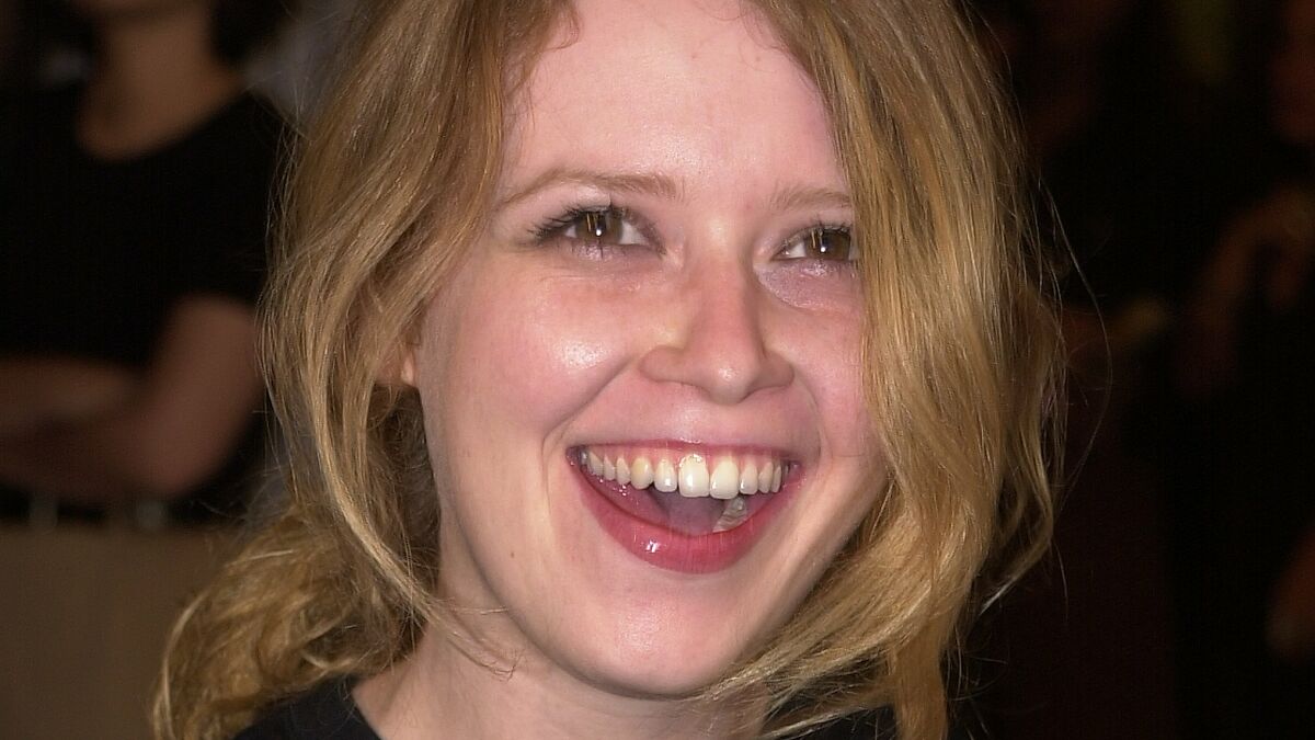 Young smiling woman with blonde hair representing celebrities who experienced homelessness in an indoor setting.