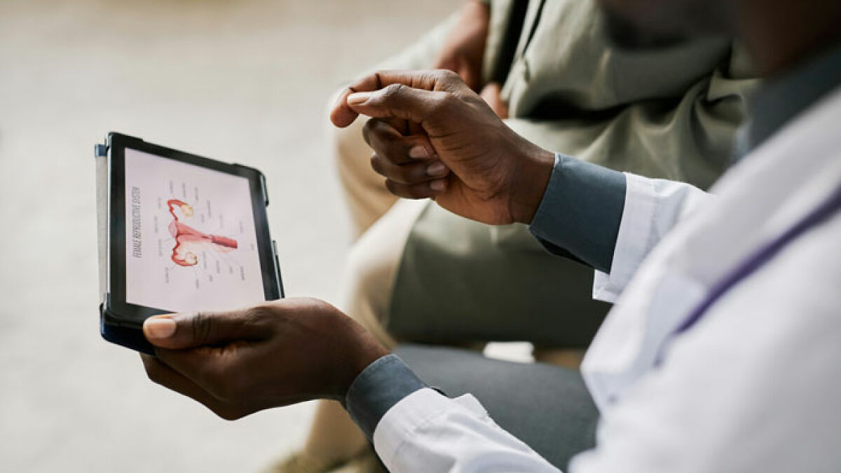 Doctor explaining reproductive health on a tablet, discussing unusual case of hair and teeth growing inside a 9-year-old girl.