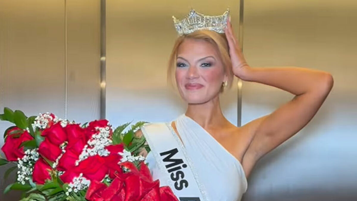 Newly crowned Miss America wearing a crown and sash, holding roses, with visible makeup flaws on her face.