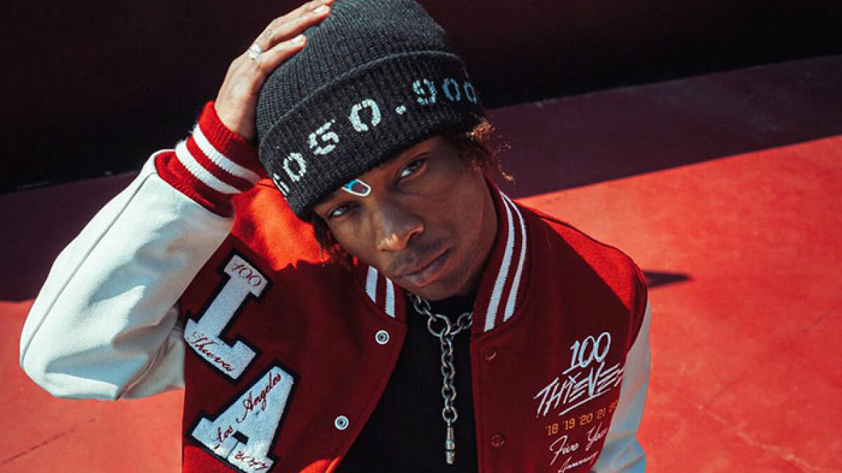 Young singer in a red and white jacket and black beanie posing, linked to decomposing body found in abandoned Tesla.