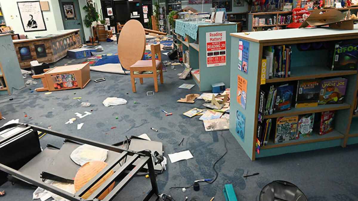 Library room in disarray with overturned furniture and scattered items, highlighting aftermath involving children aged 12 and 13.