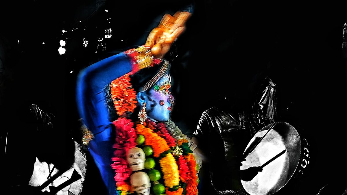 Traditional Indian dancer with colorful face paint and garlands performing in a vibrant Nat Geo India calendar setting