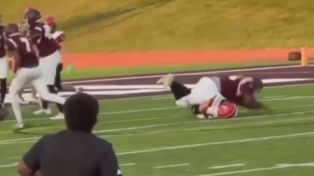 High school football game moment showing player tackling rival, highlighting strong and decisive action by the school.