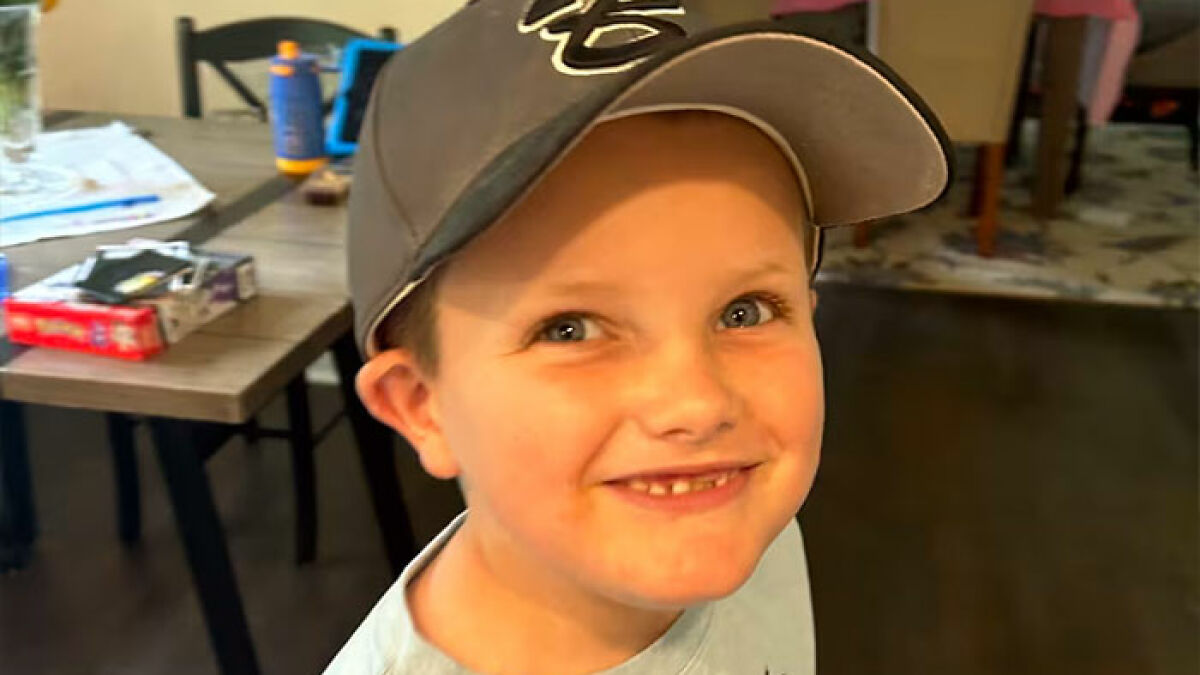Young boy smiling indoors, highlighting patient experience and healthcare communication challenges.