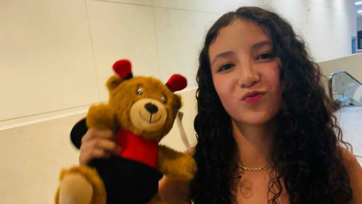 Teen girl with curly hair holding a teddy bear, connected to story about doctor suspended after fatal breast surgery.